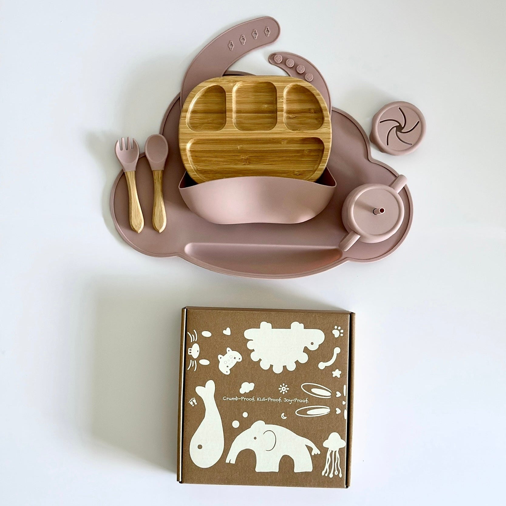 Silicone and bamboo baby feeding set with suction plate, bowl, utensils, adjustable bib, and toddler-safe packaging.”